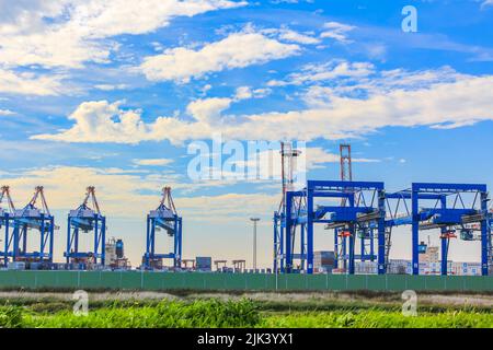 Zone industrielle grues et phare de la tour rouge avec de belles prairies et dike dike nature paysage marin panorama à Imsum Geestland Cuxhaven Bas Saxo Banque D'Images