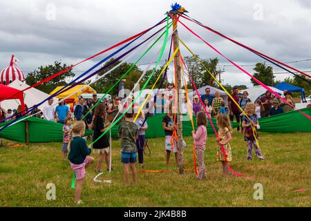 Chettle, Dorset, Royaume-Uni. 30th juillet 2022. Des milliers de personnes affluent vers le village original de Chettle, probablement le plus original du pays, pour voir ou se garer dans les événements enchayants. Beaucoup de Voyage de grandes distances pour profiter d'une drôle d'action bourrée de jour, la collecte de fonds pour la charité. Les enfants participent à la danse Maypole. Crédit : Carolyn Jenkins/Alay Live News Banque D'Images