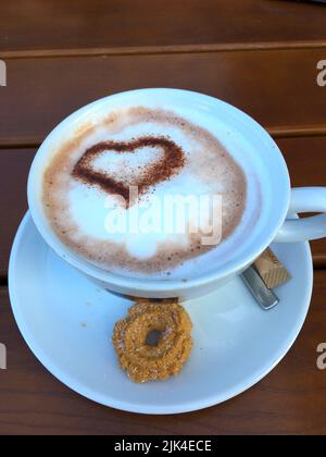 Tasse Cappuccino mit einem Herz aus Kakao verziertem Milchschaum Banque D'Images