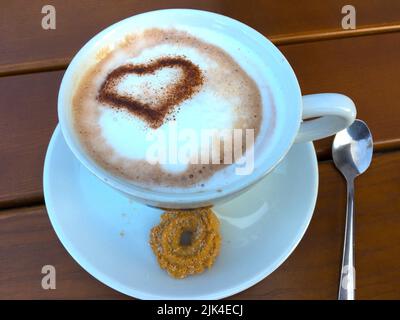 Tasse Cappuccino mit einem Herz aus Kakao verziertem Milchschaum Banque D'Images