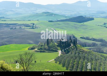 Ferme solitaire sur une colline dans les prés de Toscane, Italie Banque D'Images