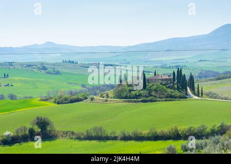 Ferme solitaire sur une colline dans les prés de Toscane, Italie Banque D'Images