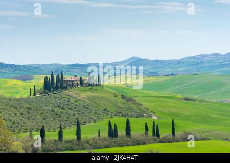 Ferme solitaire sur une colline dans les prés de Toscane, Italie Banque D'Images