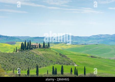 Ferme solitaire sur une colline dans les prés de Toscane, Italie Banque D'Images