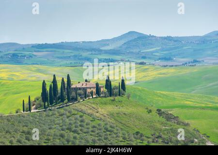 Ferme solitaire sur une colline dans les prés de Toscane, Italie Banque D'Images