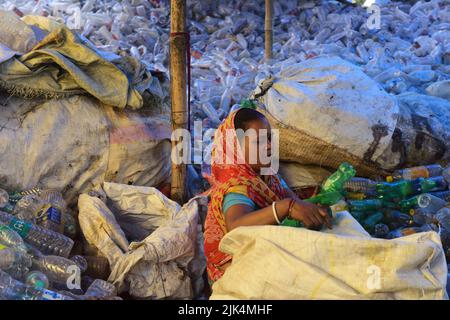 Une femme a vu trier des bouteilles en plastique dans un atelier avant des envoyer pour recyclage. Les bouteilles en plastique sont recyclées et transformées en polyester, utilisé dans les vêtements et les maillots partout dans le monde. De nombreux pays ont commencé à interdire les plastiques à usage unique pour s'attaquer aux problèmes environnementaux. Banque D'Images