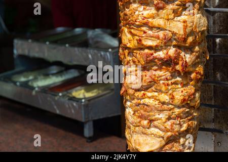 Gros plan de torréfaction de viande empilée à utiliser dans la préparation de gyros traditionnels grecs ou de doner turc. Espace de copie avec arrière-plan flou Banque D'Images