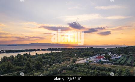 La plage de Glarokavos et le port près du village de Pefkochori. Sable doux, eaux peu profondes et pins. Couleurs du ciel incroyables au coucher du soleil. Photo de haute qualité Banque D'Images