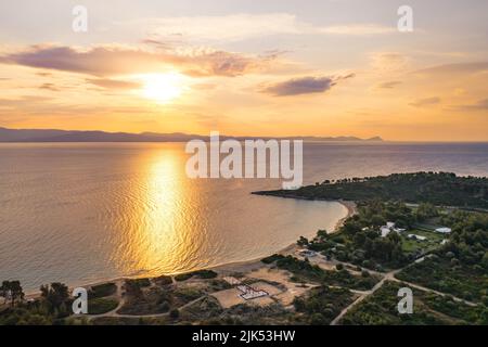 Longue plage de sable de Glarokavos située dans une baie avec une forêt de pins. Lever ou coucher de soleil sur l'eau. Photo de haute qualité Banque D'Images