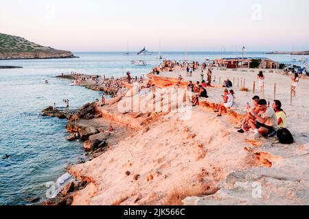 Ibiza, espagne - 28 juillet 2022 : la femme profite du coucher de soleil sur la rive d'une plage paradisiaque pendant ses vacances d'été. Banque D'Images