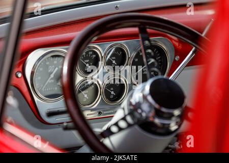 Jauge de carburant et autres cadrans sur un pick-up américain Ford F100 des années 1950. Vue par la vitre latérale et par le volant personnalisé Banque D'Images