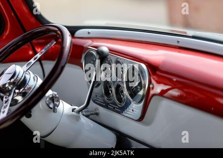 Tableau de bord, volant et jauges sur un pick-up Ford F100 des années 1950 personnalisé avec panneau de commande en acier inoxydable, cadrans et charpente métallique rouge Banque D'Images