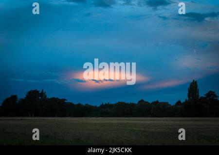 Rainbow Cloud : une formation de nuages qui recentre la lumière du soleil pour produire les couleurs de l'arc-en-ciel. Le coucher du soleil se trouve derrière la caméra. Banque D'Images