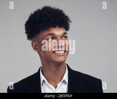L'avenir est pour ceux qui ont de la vision. Photo studio d'un jeune homme d'affaires regardant loin avec soin sur fond gris. Banque D'Images