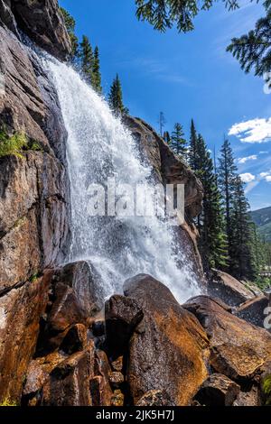 Vue latérale des puissantes chutes d'Ouzel par une journée ensoleillée dans le bassin sauvage du parc national des montagnes Rocheuses, Colorado. Banque D'Images