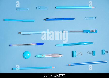 Stylos crayons compas des trombones disposés en lignes tout bleu et fond, concept pour les articles de papeterie d'école et pour les affaires Banque D'Images