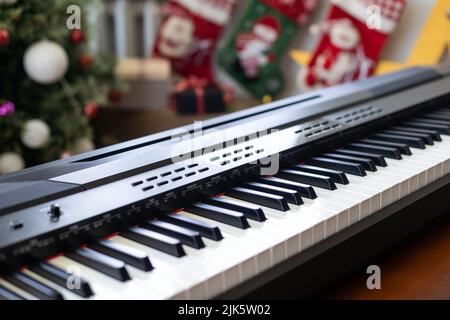 Composition du nouvel an sur un synthétiseur musical. Lumières d'une guirlande.Carte de vœux de joyeux Noël.Bonne année Banque D'Images