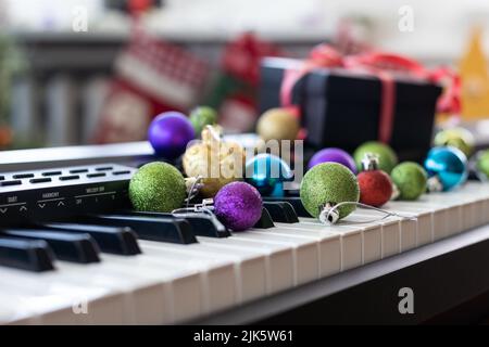 Composition du nouvel an sur un synthétiseur musical. Lumières d'une guirlande.Carte de vœux de joyeux Noël.Bonne année Banque D'Images