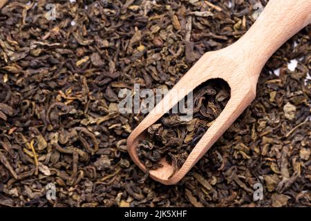 Sécher la feuille de thé verte sur fond de texture de la cuillère. Vue de dessus. Banque D'Images