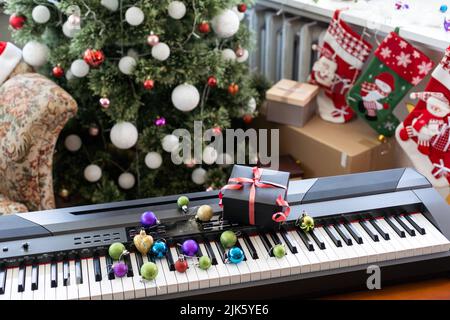 Composition du nouvel an sur un synthétiseur musical. Lumières d'une guirlande.Carte de vœux de joyeux Noël.Bonne année Banque D'Images