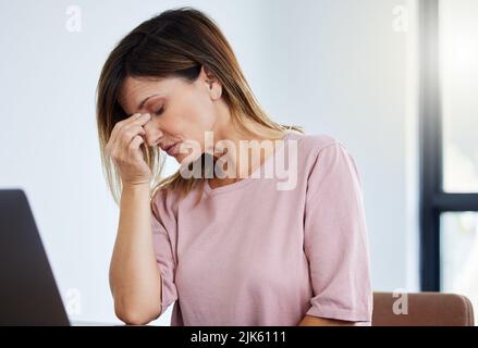 Je ne pense pas que je puisse faire aujourd'hui. Une femme de direction qui souffre d'un mal de tête au travail. Banque D'Images