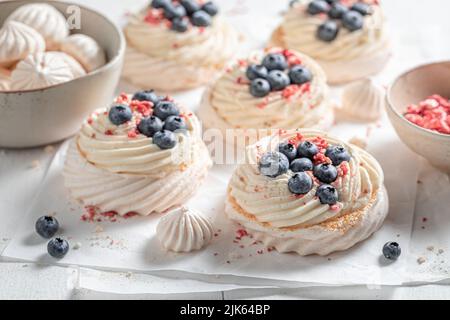 Dessert Pavlova crémeux et doux avec fruits et meringue blanche. Mini-dessert Pavlova avec framboises et bleuets. Banque D'Images