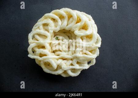 kerupuk ou krupuk ou craquelins isolés sur fond noir. kerupuk est un en-cas à base de pâte de farine de tapioca mélangée à des arômes tels que crevettes ou fi Banque D'Images