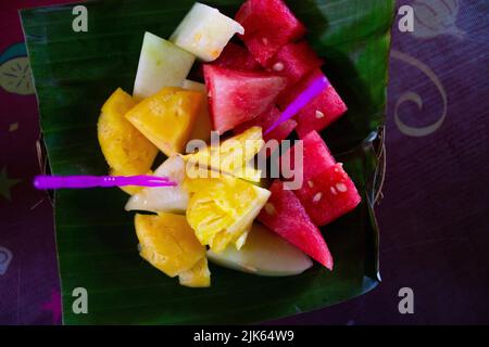 salade de fruits frais servie sur feuille de banane. salade de pastèque et tranche d'ananas Banque D'Images