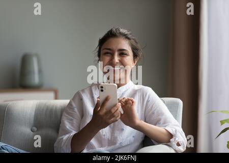 Bonne femme indienne millénaire en utilisant un smartphone Banque D'Images