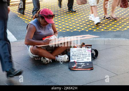 Sans-abri artiste australien indigène assis à pieds croisés sur le trottoir faisant des peintures au coin de Market Street et George Street à Sydney. Elle vendait son art pour $50 une pièce. Banque D'Images