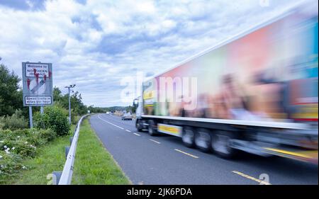 Camion passant le panneau de la frontière défacé entre la République d'Irlande et l'Irlande du Nord, Belfast-Dublin Road Banque D'Images