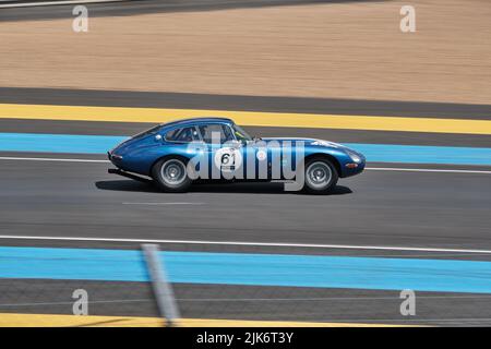 Une voiture de course Jaguar de classe qui se conduit rapidement de gauche à droite sur le circuit du Mans Banque D'Images