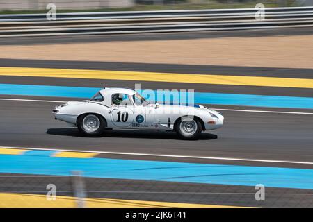 Une voiture de sport classique blanche qui se conduit rapidement de gauche à droite Banque D'Images