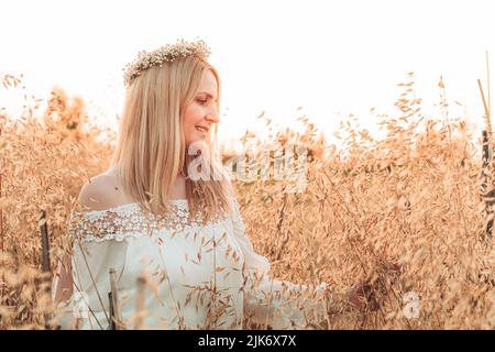 Jeune femme blonde debout dans le champ de blé Banque D'Images