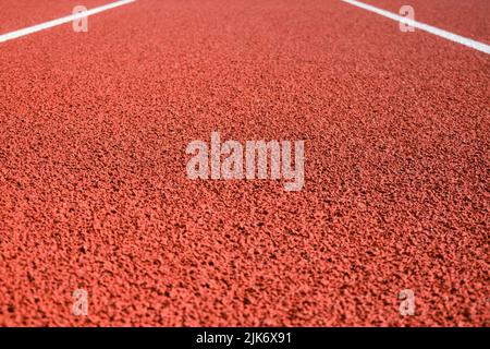 Stade de sport avec pistes de course à pied en caoutchouc artificiel rouge et lignes blanches Banque D'Images