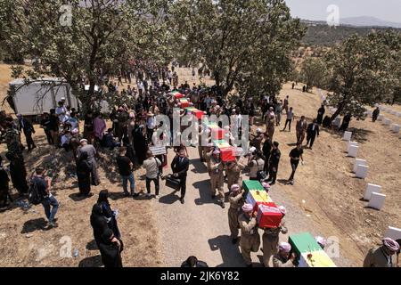 Barzan, Irak. 31st juillet 2022. Les hommes kurdes portent des coffres contenant les restes de 100 victimes Barzani, qui ont été tuées dans les opérations d'Anfal à la fin de 1980s, lors d'une cérémonie d'enterrement au cimetière d'Anfal à Barzan. Le régime de l'Irak baathiste, dirigé par Saddam Hussein, a mené des opérations violentes contre les Kurdes à la fin de 1980s, laissant au moins 182 000 morts et 90% des villages kurdes détruits. Credit: Ismael Adnan/dpa/Alay Live News Banque D'Images