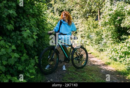 Une jeune femme utilise un vélo électrique moderne pour le sport et les loisirs de plein air Banque D'Images