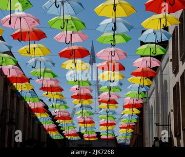 Parasol suspendu coloré avec ciel bleu. Cardiff Scenes, juillet 2022. Été. Logos d'assurance Admiral Banque D'Images