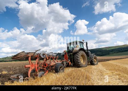 Labourage en chaume sur un terrain arable avec un tracteur John Deere 6155M et une charrue réversible à 5 sillons. North Yorkshire, Royaume-Uni. Banque D'Images