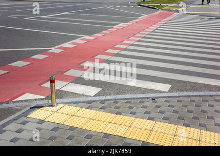 passage pour piétons avec dents et marquages rouges pour le mouvement des bicyclettes sur la chaussée Banque D'Images