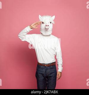 Portrait d'un homme portant un masque lama blanc sur fond rose Banque D'Images