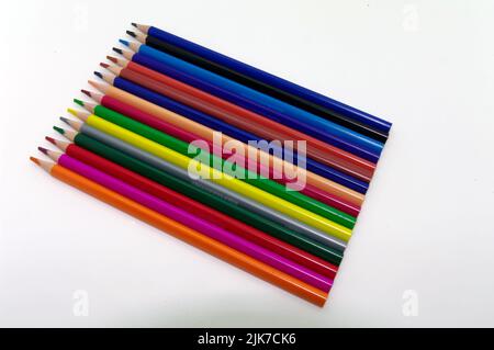Peinture et dessin : différents crayons de couleur soigneusement disposés en parallèle sur un fond blanc Banque D'Images