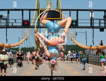 Halifax, Canada. 31 juillet 2022. Les acrobates se présentant au milieu du pont tandis que des centaines prennent leurs chaussures de marche pour prendre le pont Angus MacDonald Memorial Bridge lors de la promenade annuelle du pont. Le pont MacDonald qui relie Halifax à Dartmouth aujourd'hui est libre de voiture pour permettre aux piétons de profiter de la vue sur le port et de marcher d'un côté à l'autre. Credit: Meanderingemu/Alamy Live News Banque D'Images