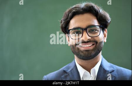 Jeune homme d'affaires indien souriant portant un costume et des lunettes. Portrait de tête Banque D'Images