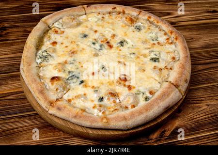 Pizza avec quatre fromages, mozzarella, fromage bleu, parmesan. Cuisine italienne. Sur fond en bois. Vue de dessus Banque D'Images