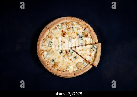 Pizza avec quatre fromages, mozzarella, fromage bleu, parmesan. Cuisine italienne sur fond noir. Vue de dessus Banque D'Images