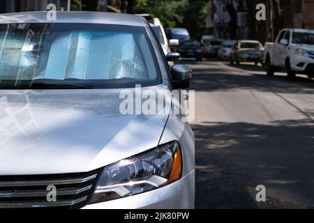 Surface réfléchissante protectrice sous le pare-brise de la voiture par temps chaud, chauffée par les rayons du soleil à l'intérieur de la voiture Banque D'Images