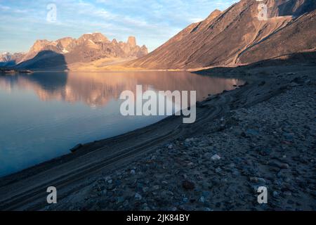La tour en granit de Mt.Asgard et les pics environnants se reflètent dans les eaux du lac Glacier, dans la vallée arctique éloignée du col Akshayuk, île de Baffin, Canada Banque D'Images
