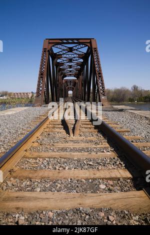 Gros plan des voies ferrées menant au pont de chemin de fer en acier rouillé, Laval, Québec, Canada. Banque D'Images