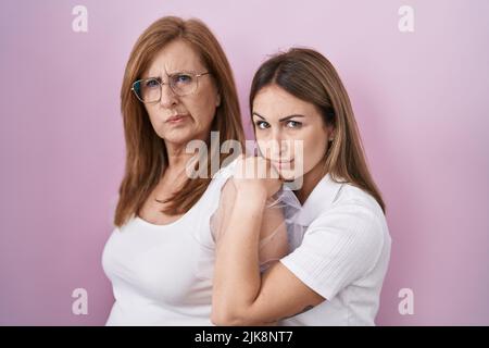 Mère hispanique et fille portant décontracté t-shirt blanc sceptique et nerveux, frowning bouleversé à cause du problème. Personne négative. Banque D'Images